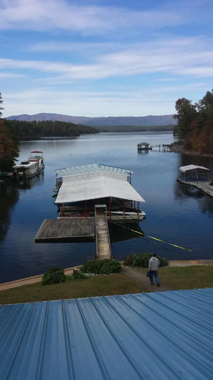View across a lake from a newly installed blue metal roof in Plymouth